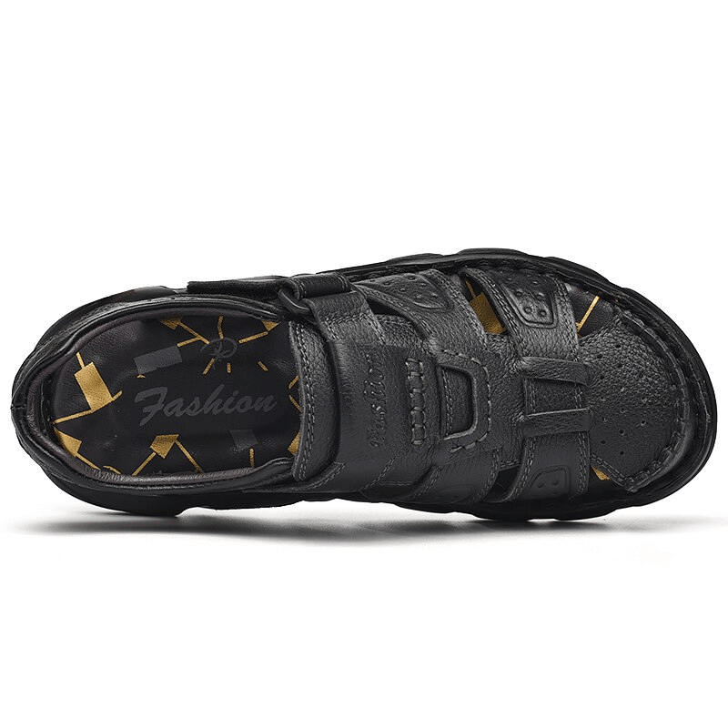 Top view of black leather trekking sandal with adjustable hook & loop closure, featuring anti-collision toes and comfortable sole.